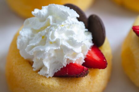 Biscuit cakes with fresh strawberries, blueberries, chocolate, and whipped heavy cream. Fresh mini biscuit cups close up on white background.の写真素材