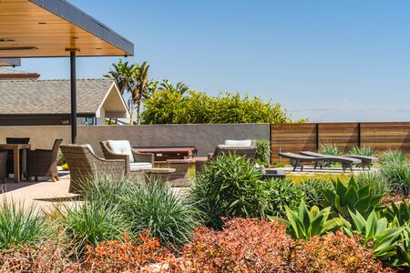 Beautiful beach house with nicely landscaped of front the yard, with tropical plants and outdoor furnitureの写真素材