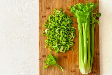 Sliced fresh celery close up on wooden cutting board on white background with copy spaceの写真素材