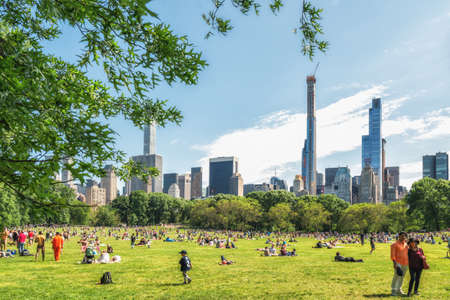 New York City/USA - May 25, 2019 
 People Resting in  Central Park, Beautiful Sunny Day in New York City. Manhattan Skyline as it viewed from the Park.のeditorial素材