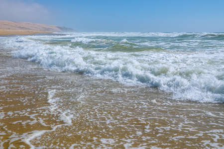 Sunny day on the beach.  Blue waves breaking on the shore. Empy tropical beach, summer, relax conceptの写真素材