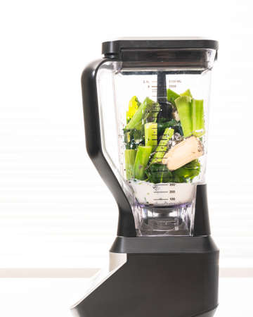 Blender with ingredients close up on white background. Celery spinach banana smoothie recipe.の写真素材