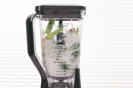 Mixing ingredients in blender. Celery spinach banana smoothie recipe.の写真素材