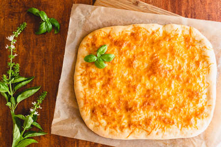 Homemade flat bread with cheeseand basil closeup on wooden backgroundの写真素材