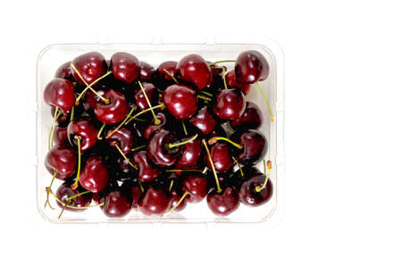 Cherries in plastic container isolated on white background directly from above with copy spaceの写真素材