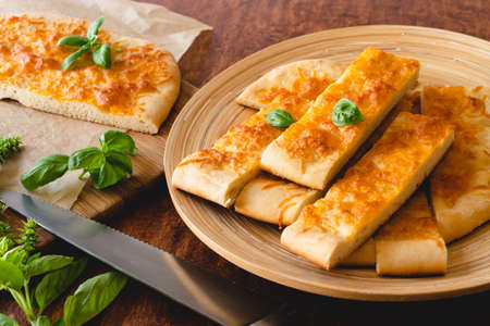 Homemade flat bread with cheeseand basil closeup on wooden backgroundの写真素材