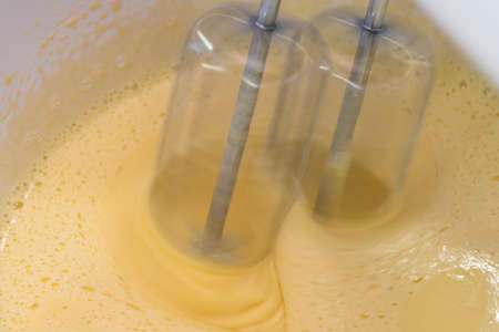 Mixing biscuit dough with an electic mixer. close up process. Cake batter making.の写真素材