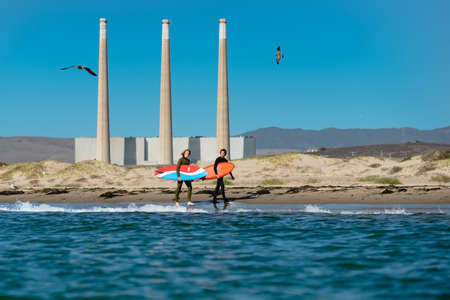 Morro Bay, California/USA-September 23, 2020  Friends, two young men, wearing in wet suits with...