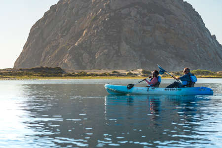 Morro Bay, California/USA - September 23, 2020  Kayaking in the harbor and estuary. Mature couple enjoying view of Morro Bay harbor. Famous landmark, volcanic Morro Rock on backgroundのeditorial素材