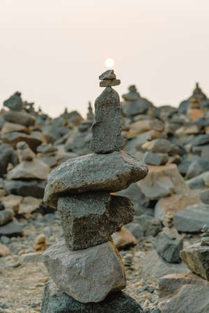 Stone pyramid on the beach at sunset. Balance, tranquility, harmony conceptの写真素材