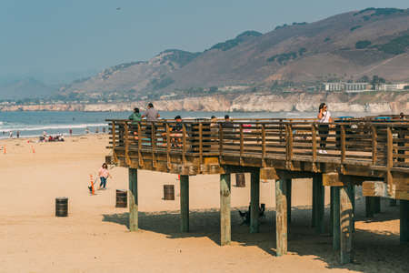 Pismo Beach, California/USA - October 4, 2020  Pismo Beach wooden boardwalk, resting people, and wide sandy beach. Pismo Beach, San Luis Obispo County, California Coastlineのeditorial素材