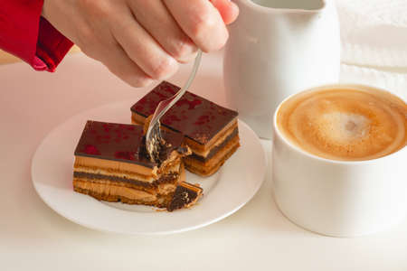 Cup of coffee with milk, and chocolate cake. Sweet delicious breakfast on a bed tray tableの写真素材