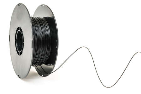 3D Printer Plastic Filament. Spool of black thermoplastic wire for 3D printing close up isolated on white backgroundの写真素材
