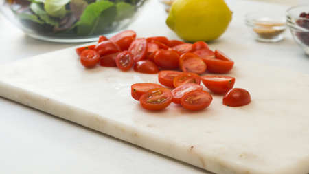 Cherry tomatoes close up on cutting board. Vegetable salad recipeの写真素材