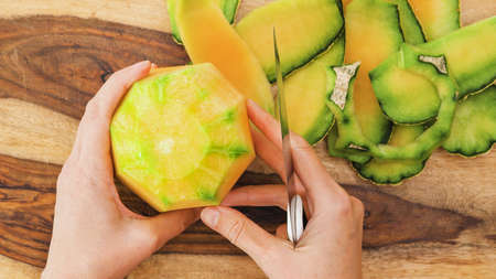 Peeled cantaloupe melon close up on wooden cutting boardの写真素材