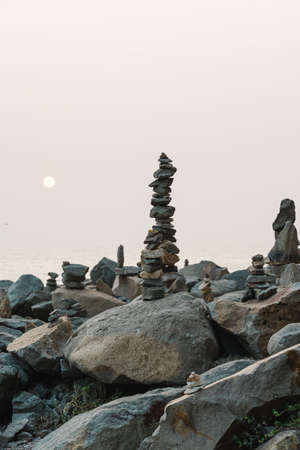Stone pyramids on the beach at sunset. Balance, tranquility, harmony conceptの写真素材