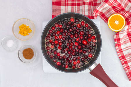Cranberry sauce being heated up in a pan, close up view from above. Cranberry sauce recipe, cooking conceptの写真素材