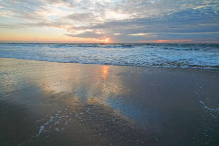 Tranquility scene, beautiful tropical beach sunset in light pink and blue colors with beautiful sun reflection on the beachの写真素材