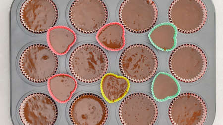 Chocolate cupcakes recipe. Cupcake pan lined with paper liners, and silicon molds filled with...