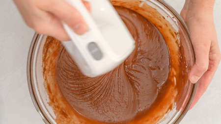 Mixing chocolate batter using an electric mixer. Chocolate muffins or chocolate cupcakes recipe