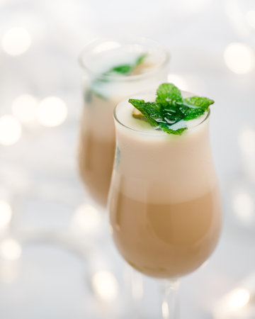Cream liquor with frozen ice mint leaves close up in glasses on light background with bokehの写真素材