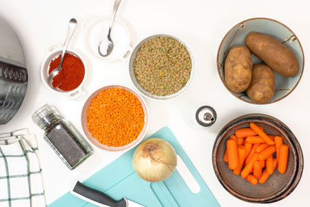 Lentil soup ingredients.  Red lentils, green lentils, onion, carrot, potatoes, and some seasoning close up on white backgroundの写真素材