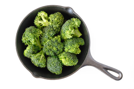 Broccoli florets in a frying pan close up isolated on white background, top view, copy spaceの写真素材