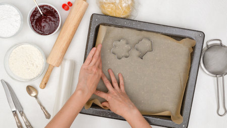 Woman hands line baking pan with parchment paper. Shortbread cookie recipe. Step by step baking...