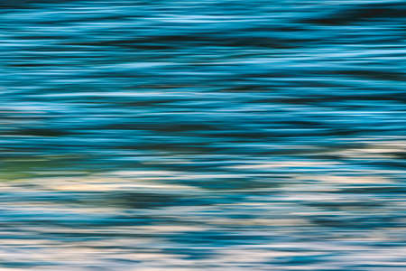 Water surface dark blue abstract background, play of ripples, copy space