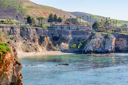 Pismo Beach, California, USA - March 1, 2021  Pismo Beach cliffs, beach hotels, and ocean view in sunny day. Green hills, palm trees and clear blue skyon backgroundのeditorial素材