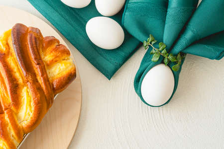 Baked yeast cake staffed with cream cheese, and white eggs close up on white background, flat lay...