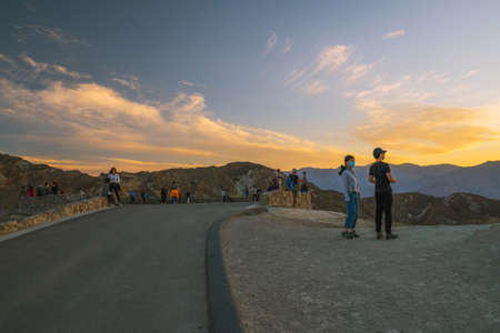 Death Valley, California, USA- April 14, 2021  Zabriskie point sunset,  one of the most popular spots in Death Valley National Park to see sunset. Tourists overlooking valley.のeditorial素材