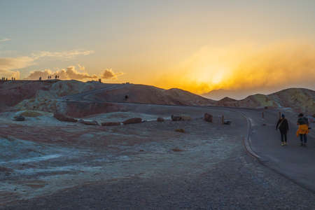 Death Valley, California, USA- April 14, 2021  Zabriskie point sunset,  one of the most popular spots in Death Valley National Park to see sunset. Tourists overlooking valley.のeditorial素材