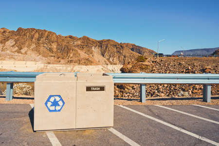 Trash and recycle beans on parking lot in public park. Mountains and blue sky background, copy space. Environment protection, pollution, recycling and throwing away trash or waste conceptの写真素材
