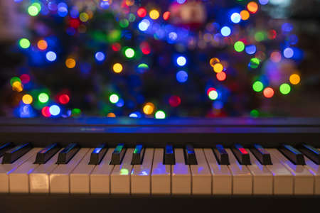 Piano keyboard and Christmas pine tree illuminations. Vibrant colors, Holidays conceptの写真素材