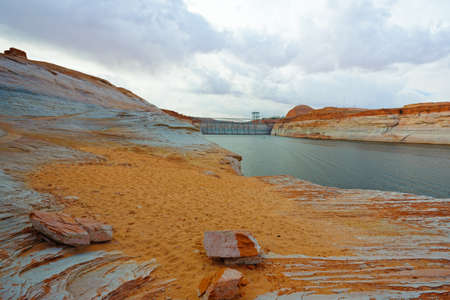 View of Glen Canyon dam from the beach at Chains trail, cloudy sky backgroundの写真素材