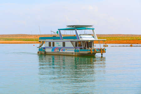 Lake Powell, Utah, USA - September 29, 2021 Houseboat on Lake Powell in Utah, long beautiful coastline and cloudy sky on backgroundのeditorial素材