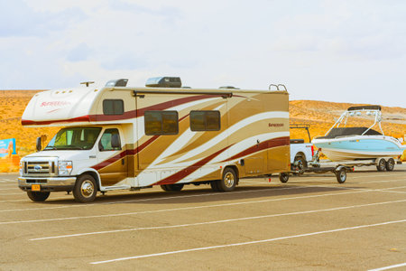 Lake Powell, Utah, USA - September 29, 2021 Travel trailer towing a boat. Lake Powell beach, parking...