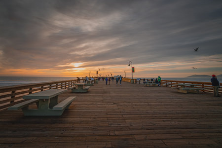 Pismo Beach, California, USA - January 1, 2021 Pismo Beach pier at sunset with walking people enjoying ocean view and beautiful cloudy sky on backgroundのeditorial素材