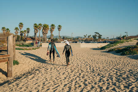 Oceano, California, USA- January 22, 2022. Sand beach, wooden boardwalk with walking people, palm trees and blue sky. Oceano, small beach town in California Central Coastのeditorial素材