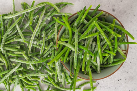 Frozen green beans, haricots verts,  close up in a bowl, flat lay. Fresh raw vegetable food...