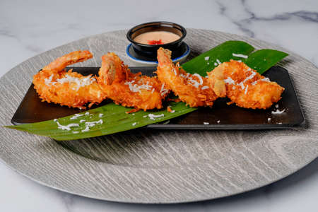 Fried coconut shrimp served with cocktail sauce close up on a plateの写真素材