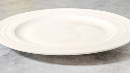 White ceramic plate close-up on grey backgroundの写真素材