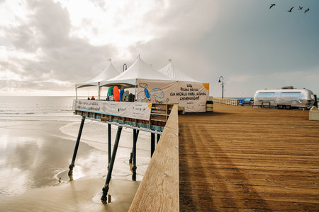 Pismo Beach, California - December 6, 2022.  Pismo beach pier during ISA World Para Surfing Championship. Long wooden pier, sandy beach, and ocean view.のeditorial素材