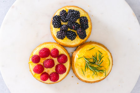 Mini cheesecakes close-up, top view. Cheesecake topping ideas. Fresh berries topping, and rosemary...