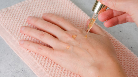 Woman hands applying glow daily serum, close-up viewの写真素材