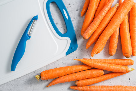 Carrots close-up. Fresh raw organic carrot on a light grey stone background, view from aboveの写真素材