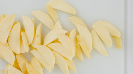 Apple slices close up on a white cutting board on the kitchen table, flat lay with copy space, apple cake recipeの写真素材