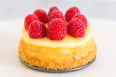 Mini cheesecake with raspberries close-up on the kitchen table. Homemade delicious dessert, breakfast, sweet holiday treatの写真素材
