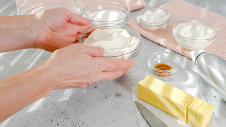 Cheesecake recipe. Ingredients close-up on the kitchen table. Cream cheese, eggs, butter, sugar, crackers, vanilla, yogurt, and corn starch on gray backgroundの写真素材